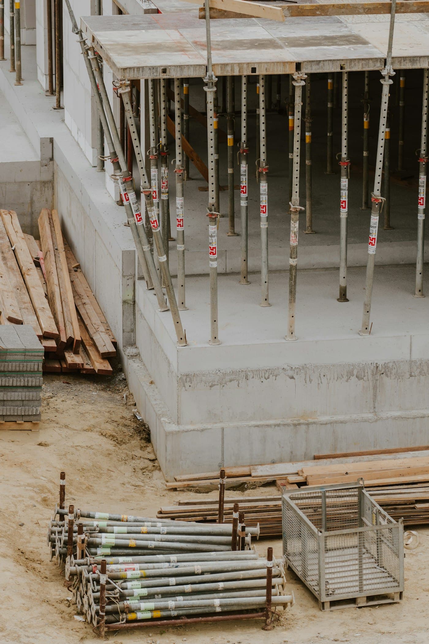Deckenschalung mit Baustützen über einer Betonwand